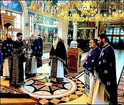 Grupa sveštenika u ljubičastoj i crnoj odeždi kleče u molitvi na mermernom podu Hrama Preobraženja Gospodnjeg na Zlatiboru tokom Svete Tajne ispovesti sveštenstva. U fokusu je Časna Trpeza sa crvenim pokrivačem i svećnjacima, u dubokom enterijeru hrama sa detaljnim vizantijskim freskopisom