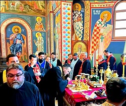 Zajednička molitva i poklonjenje grupe sveštenika Arhijerejskih namesništava užičkog i račanskog pred Časnom Trpezom u oltarskom delu Hrama Preobraženja Gospodnjeg na Zlatiboru. Sveštenici se klanjaju i celuju bogoslužbene predmete u prisustvu duhovnika, sa vidljivim svećama i zlatnim posuđem tokom bratokrajne ispovesti