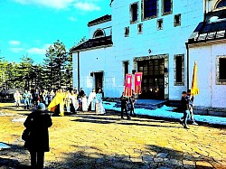 Свечана литија поводом празника Врбица (Лазарева субота) 2026. године у порти Храма Преображења Господњег на Златибору. На слици се види велика колона верника и деце са звончићима и врбовим гранчицама која се креће стазом кроз четинарску шуму. На челу поворке су црквени барјаци и дечаци у стихарима. Фотографија наглашава дух православне заједнице и прославу Васкршњих празника на Краљевском Златибору, под покровитељством црквене општине чајетинске